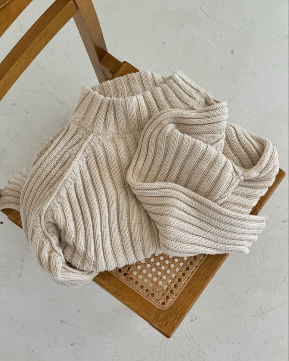 Ribbed cream knit folded on a cane and wood chair