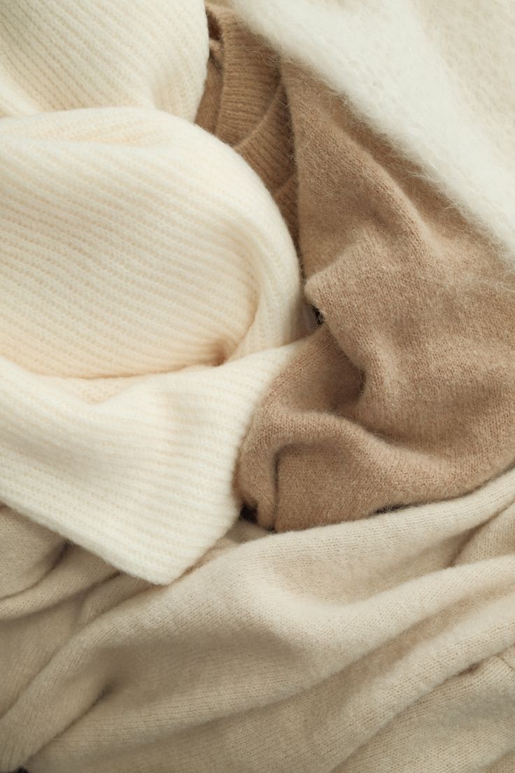Soft cream and camel knits folded together, close up